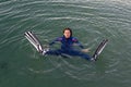 Beach vacation fun woman wearing a wetsuit and flippers making a goofy face while swimming in ocean water Royalty Free Stock Photo