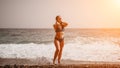 A tourist woman in blue bikini on beach enjoys the turquoise sea during her summer holiday. Rear view. Beach vacation Royalty Free Stock Photo