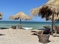 Beach in Vama Veche resort, with wooden sunbeds and reed umbrellas