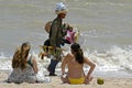 Beach vendor and women sunbathers, Brazil