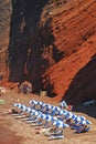 Red beach at Santorini, Greece with sunbathing blue white umbrella & sundeck for visitors popular for its titular red hued sand