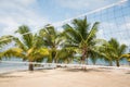 Beach volleyball field with palm trees and ocean background