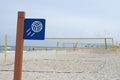 Beach volleyball sign and net on the empty beach