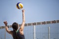 Beach volleyball woman player hits the ball with knuckles touch