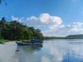 Beach water trees ships sea mountains sand beach grass blue sky clouds fishermen Royalty Free Stock Photo