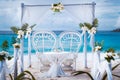 Beach wedding arch gazebo ceremonial decorated with white flowers on a tropical grand anse sand beach. Outdoor beach