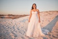 Beach wedding, bride and happy woman in a white dress while standing in sand and sun enjoying her special day at a Royalty Free Stock Photo