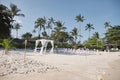 Beach wedding venue arrangement at seaside, Arch, Altar with minimal flowers decoration, palm tree and coconut background Royalty Free Stock Photo