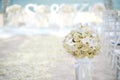 A bunch of white cream roses, orchids on the glass vase beside the aisle at the beach wedding ceremony - closed up Royalty Free Stock Photo