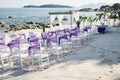 Beach wedding venue settings with white chiavari chairs decorate with violet organza sash at seaside Royalty Free Stock Photo