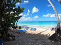 Beach with white sand, blue lounge chairs, and fluffy clouds Royalty Free Stock Photo