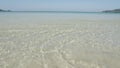 The beach with white sand and calm wave from peaceful sea in summer sunshine daytime.