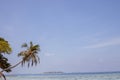 Beach with white sand, turquoise ocean, coconut palms and blue-sky background