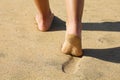 Beach woman legs feet walking barefoot on sand leaving footprints on golden sand in sunset. Vacation travel freedom people Royalty Free Stock Photo