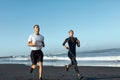 Beach. Woman And Man Running Along Coastline. Sport Couple In Fashion Sportswear On Outdoor Workout In Morning. Royalty Free Stock Photo