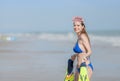 Beach woman walking by ocean. Girl in bikini with snorkel coming out of water after swimming and snorkeling in beautiful blue Royalty Free Stock Photo