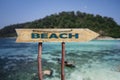 Beach wooden arrow road sign against tropical beach with white sand and turquoise water background. Travel concept Royalty Free Stock Photo