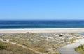 Beach with wooden boardwalk and sand dunes with grass. Blue sea and clear sky, sunny day. Galicia, Spain. Royalty Free Stock Photo