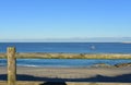 Beach with wooden fence and fishing boat. Morning light, sunny day, blue sky. Galicia, Coruna, Spain. Royalty Free Stock Photo