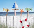 Beach and Wooden Plank Fence with Hands Holding Toys Royalty Free Stock Photo