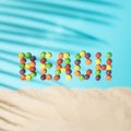 Beach word made from colored balls on a blue background with palm leaf shadow and sand. Tropical summer flat lay beach concept Royalty Free Stock Photo