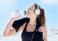 Beach, workout and drinking water with headphones music for exercise, fitness and training break. Wellness, relax and Royalty Free Stock Photo