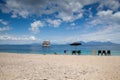 A deserted beach with an umbrella on one of the Islands of the Great Barrier Reef in Australia. A small white ship is a little to