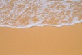 Beach yellow sand covered with wave white foam