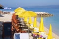 Beach yellow umbrellas and chaise for relax and comfort on sea coast. Happy summer vacations and tourism concept. Paid service on