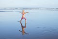 Beach yoga. Caucasian woman practicing Virabhadrasana II, Warrior II Pose. Strong body. Healthy lifestyle. Water reflection. Yoga Royalty Free Stock Photo