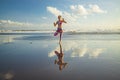 Beach yoga. Vrikshasana asana. Slim woman practicing tree pose. Water reflection. Balance and concentration. Healthy lifestyle. Royalty Free Stock Photo