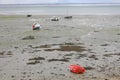 beached boats and a small red rowing boat at low tide in France in Brittany