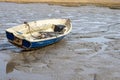 A beached rowing boat, fishing boat in the mudflats in Essex, England.