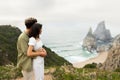 Beachfront bliss. Couple in love having romantic date, man embracing lady from back, standing together at coastline Royalty Free Stock Photo