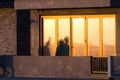 Beachgoers reflections at windows of a  beach house brightly lid by sunset Royalty Free Stock Photo