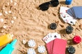 Beachpoker. Chips and cards on the sand. Around the seashells, sunglasses and suntan cream. Top view Royalty Free Stock Photo