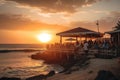 beachside restaurant, with the sun setting beyond the horizon and patrons enjoying sunset cocktails