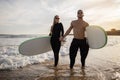 Beachside Romance. Portrait Of Young Happy Couple Surfing Together On The Beach Royalty Free Stock Photo