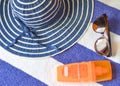 Beachware and accesories on blue-white towel background.