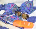 Beachware and accesories on blue-white towel background.