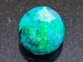 bead from Chrysocolla gemstone on dark