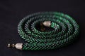 Bead crochet necklace green color on a dark background