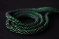 Bead crochet necklace green color on a dark background