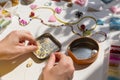 Beading workplace with hands in the process of handicraft