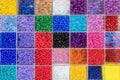 Beads are arranged and sorted by color. Background of colorful bright beads in boxes, set for needlework. Royalty Free Stock Photo