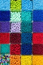 Beads are arranged and sorted by color. Background of colorful bright beads in boxes, set for needlework. Royalty Free Stock Photo