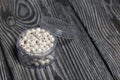 Beads for needlework. Pearl color. In a plastic jar. On pine boards painted black and white Royalty Free Stock Photo