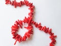 A beads from pieces of red coral on a white background