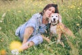 Beagle dog portrait with its woman owner looking at camera while sitting in high green grass. Female hugging her pet friend and Royalty Free Stock Photo