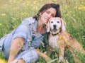 Beagle dog portrait with its woman owner looking at camera while sitting in high green grass. Female hugging her pet friend and Royalty Free Stock Photo